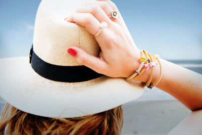 Trollbeads model at the beach wearing a leather bracelet with beads and two rings