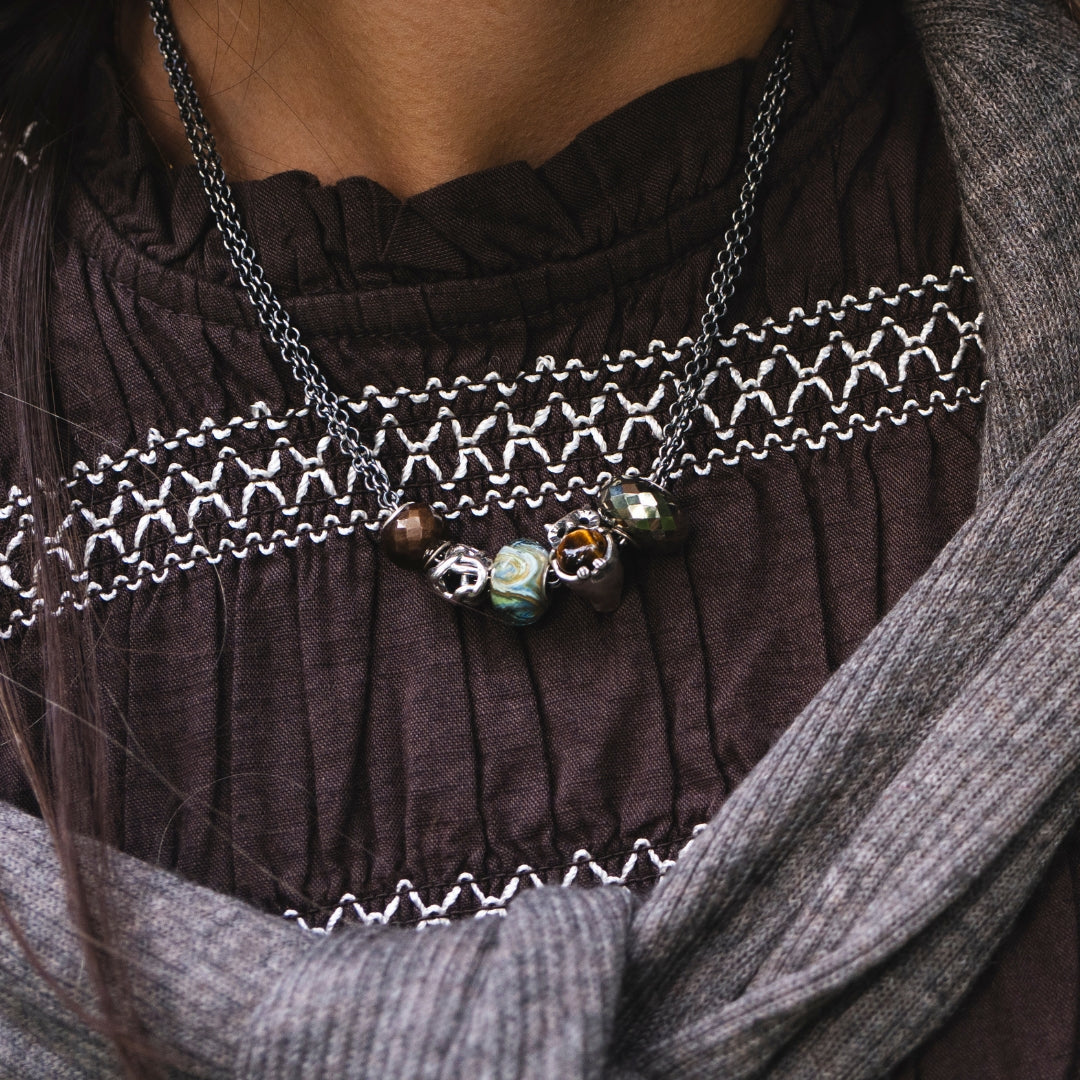Close up of a model wearing a necklace with different beads
