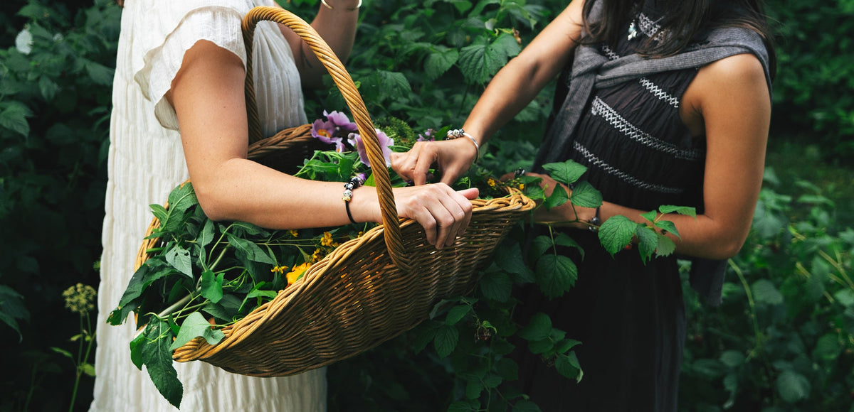Two models wearing bracelets with beads while gathering flowers in nature