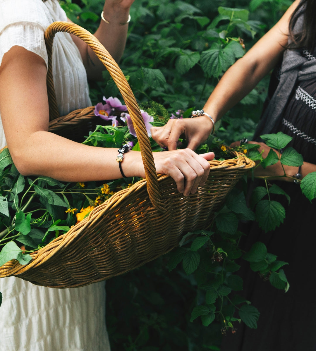 Two models wearing bracelets with beads while gathering flowers in nature